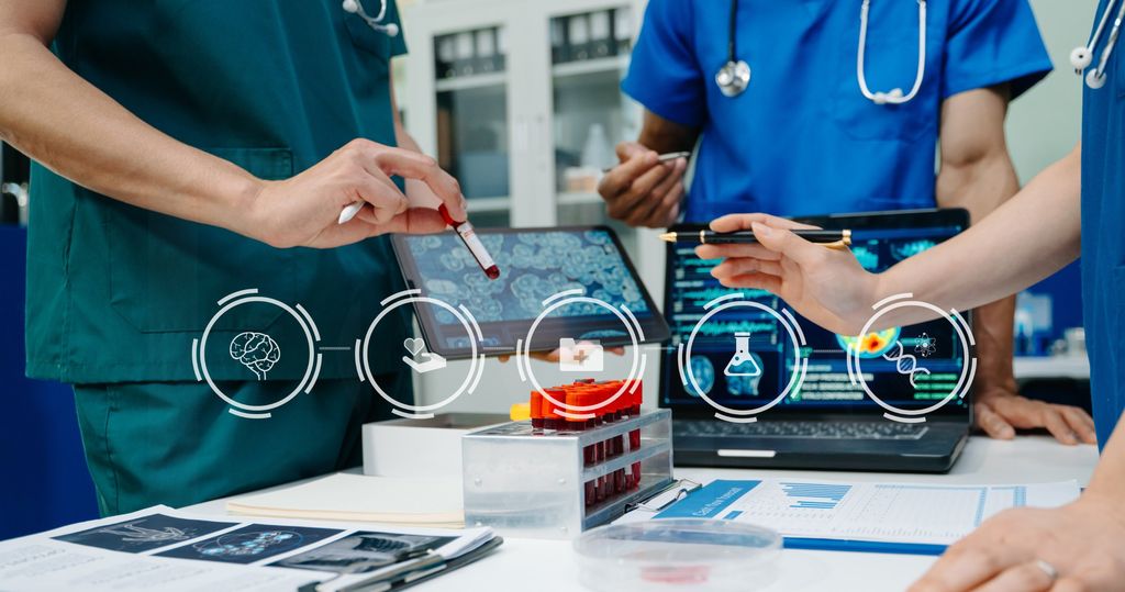 Healthcare professionals reviewing digital data on a tablet and laptop